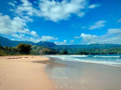 a sandy beach next to a body of water